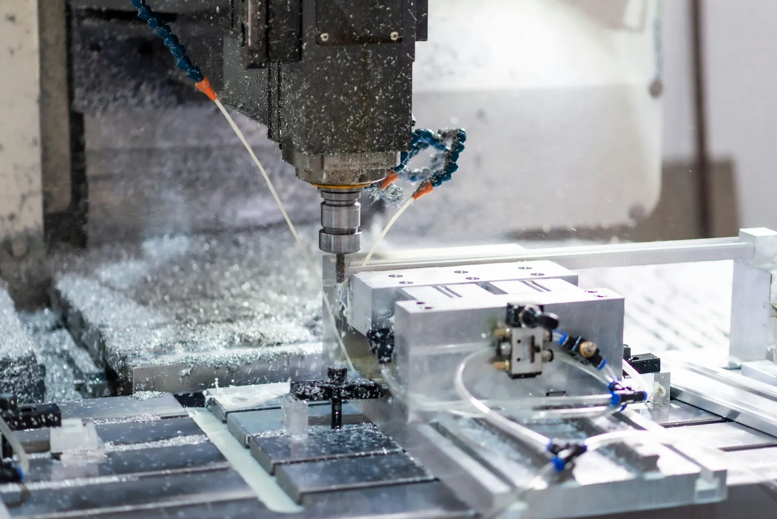 A CNC machining centre with a part clamped in a fixture on the T-slot table